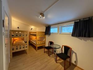 een kamer met 2 stapelbedden en een tafel en stoelen bij Kolbackens Camping & Stugby in Åsarna