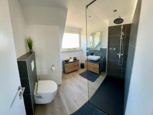 ein Badezimmer mit Dusche, Toilette und Waschbecken in der Unterkunft Eifelpause Vulkan in Bleckhausen + 19 Fotos