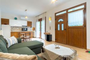 a living room with a green couch and a table at Elena's Apartment in Therma Samothrace in Therma