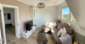 ein Wohnzimmer mit Sofa und Fernseher in der Unterkunft Eifelpause Vulkan in Bleckhausen