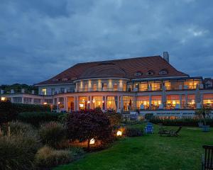 ein großes Gebäude mit nachts eingeschaltetem Licht in der Unterkunft ATLANTIC Grand Hotel Travemünde in Travemünde