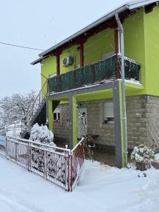 a house with a balcony in the snow at Andrić in Gračac