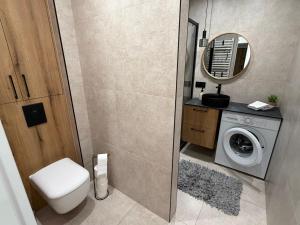 een badkamer met toilet en wasmachine bij Apartament Cichy in Tarnów