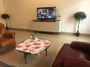 un soggiorno con tavolino e TV di Grand Appart ESSOS camp sonel a Yaoundé