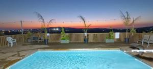 een zwembad met een zonsondergang op de achtergrond bij Aurora Golan in Buq‘ātā