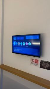 TV a schermo piatto a parete di Aurora House Surabaya a Wijung
