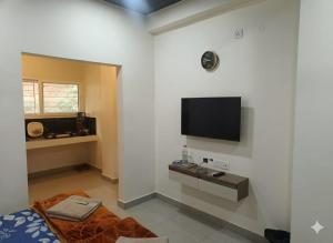 a living room with a flat screen tv on a wall at Cleanslate homestay in Guwahati