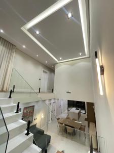 a living room with stairs and a table and a dining room at Maison Joia dos Vinhedos in Vinhedo +15 photos
