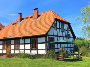 a black and white house with an orange roof at Fischerhus Lütt Hauke 75 qm Annerose in Altwarp