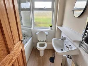 a small bathroom with a toilet and a sink at 2 Borrodale - Sleeps 4 & Beautiful Mountain View in Glendale