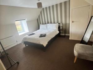 a bedroom with a bed and a window and a chair at 2 Borrodale - Sleeps 4 & Beautiful Mountain View in Glendale