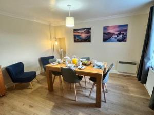 a dining room with a wooden table and blue chairs at 2 Borrodale - Sleeps 4 & Beautiful Mountain View in Glendale