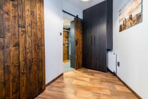 a hallway with wood paneled walls and a door at Apartmán U Hluboké studny in Rakovník