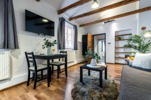 a living room with a table and chairs and a couch at Apartmán U Hluboké studny in Rakovník