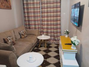 a living room with a couch and a tv at Staycation with Shicks in Nairobi