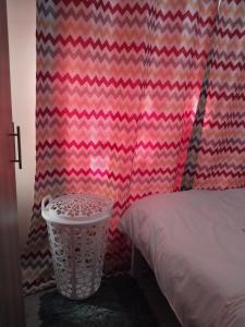 a room with a bed and a curtain with a trash can at Staycation with Shicks in Nairobi +5 photos