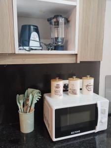 a microwave with three coffee cups on top of it at Staycation with Shicks in Nairobi