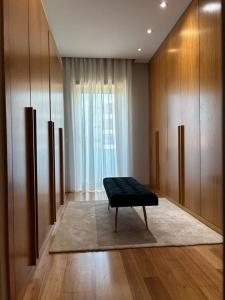 a room with a bench in a room with a window at Luxury Modern Triplex Apartment in Póvoa de Varzim