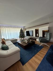 a living room with a white couch and a christmas tree at Luxury Modern Triplex Apartment in Póvoa de Varzim