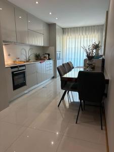 a kitchen and dining room with a table and chairs at Luxury Modern Triplex Apartment in Póvoa de Varzim