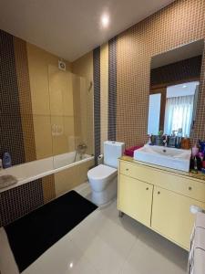 a bathroom with a toilet and a tub and a sink at Luxury Modern Triplex Apartment in Póvoa de Varzim