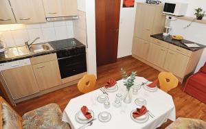a kitchen with a white table with red roses on it at Appartment Valnova / Barga in Partenen