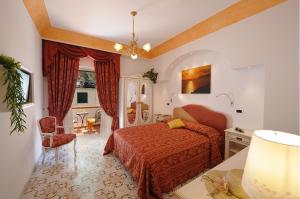 a bedroom with a red bed and a chair at Hotel La Conchiglia in Praiano