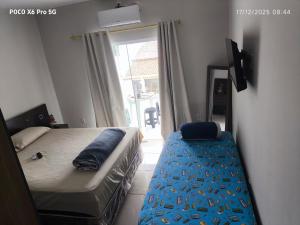 a bedroom with a bed and a large window at Alugo kitnet com café da manhã in Aparecida