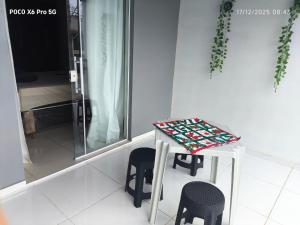a small table and two stools in a room at Alugo kitnet com café da manhã in Aparecida