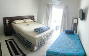 a bedroom with a large bed and a bench in it at Alugo kitnet com café da manhã in Aparecida