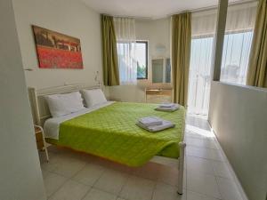 een slaapkamer met een bed met een groen dekbed bij Ivory Serenity in Theologos +21 foto's