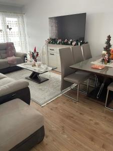 a living room with a table and chairs and a television at Apartament in Suceava +8 photos