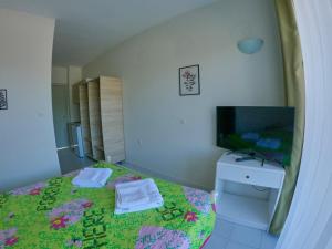 een kleine slaapkamer met een bed en een televisie bij Ivory Serenity in Theologos