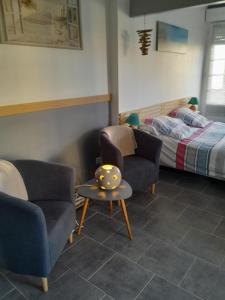 een kamer met 2 stoelen en een bed en een tafel bij Les oyats in Le Crotoy