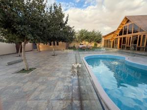 a house with a swimming pool next to a building at أكواخ كيفاء الريفية in Tabuk