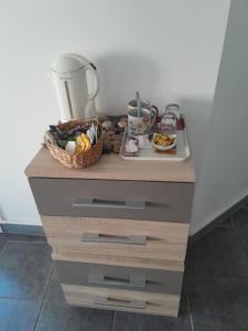 una credenza di legno con un cesto di cibo sopra di Les oyats a Le Crotoy 1 altra foto