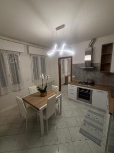 a kitchen with a table and chairs and a dining room at White Nest in Lignano Sabbiadoro