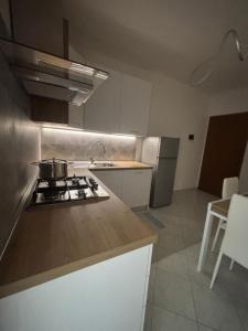 a kitchen with a stove and a counter top at White Nest in Lignano Sabbiadoro