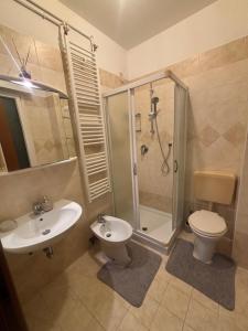 a bathroom with a sink and a toilet and a shower at White Nest in Lignano Sabbiadoro