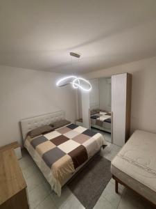 a bedroom with a bed with a checkered blanket at White Nest in Lignano Sabbiadoro