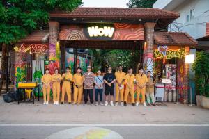 a group of people in yellow shirts standing in front of a building at Wow Tam Coc Homestay in Vũ Lâm