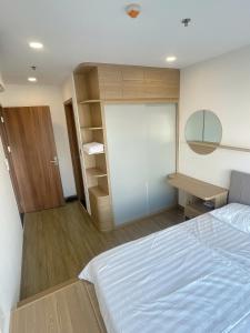 a bedroom with a bed and a desk and a mirror at Happy One Central Hottel in Trạm Chánh An