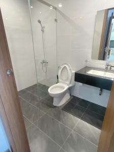 a bathroom with a toilet and a shower and a sink at Happy One Central Hottel in Trạm Chánh An