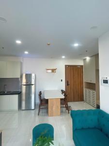 a living room with a blue couch and a kitchen at Happy One Central Hottel in Trạm Chánh An