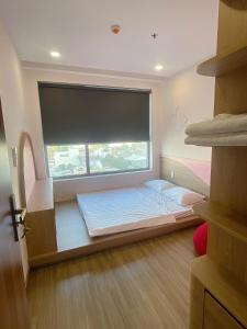 a bed in a room with a large window at Happy One Central Hottel in Trạm Chánh An +1 photo