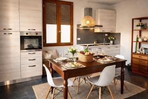 a kitchen with a wooden table and white chairs at Casa Cavour in Montecatini Terme
