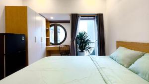 a bedroom with a large white bed and a window at Lunaria Maison - Local Side in Ho Chi Minh City