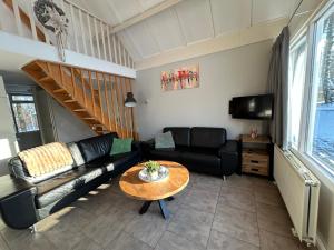 a living room with a couch and a table at Huisje 118 bungalowpark Simpelveld in Simpelveld