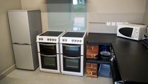 eine Küche mit Herd und Mikrowelle in der Unterkunft 3 Peaks Bunkroom in Settle