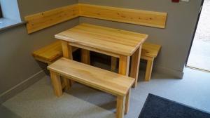 ein Holztisch und Bänke in einem Zimmer in der Unterkunft 3 Peaks Bunkroom in Settle + 1 Foto